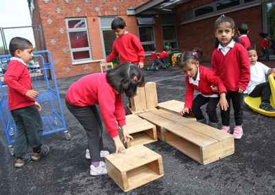Children playing with wooden blocks on playground